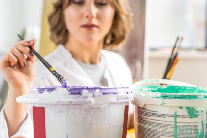 момиче с четка и консервни кутии